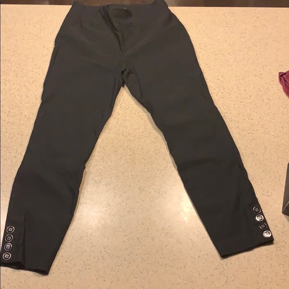 Black business pants with buttons at the ankles.